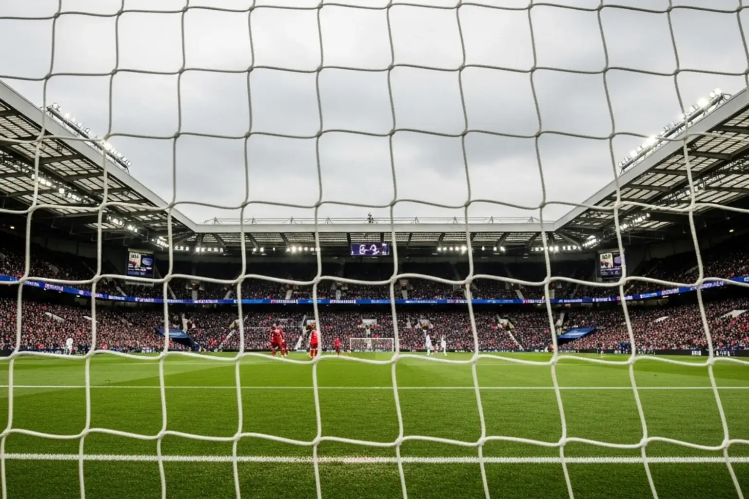 Bancada de estádio de futebol inglês vista de trás da baliza com relvado impecável
